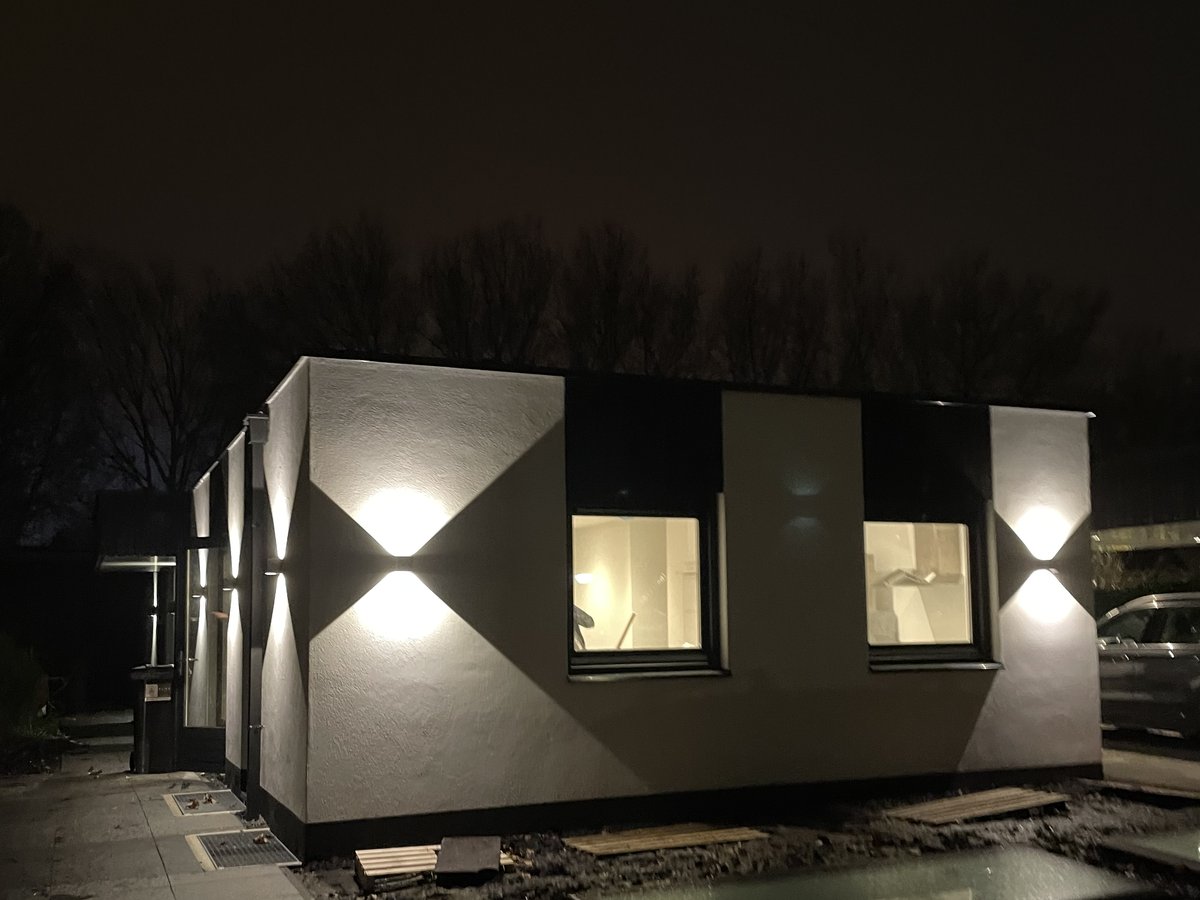 Woning in de avond met symmetrische gevelverlichting