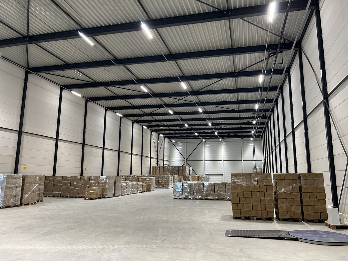Bedrijfshal in gebruik, met aangelegde verlichting boven de opslag